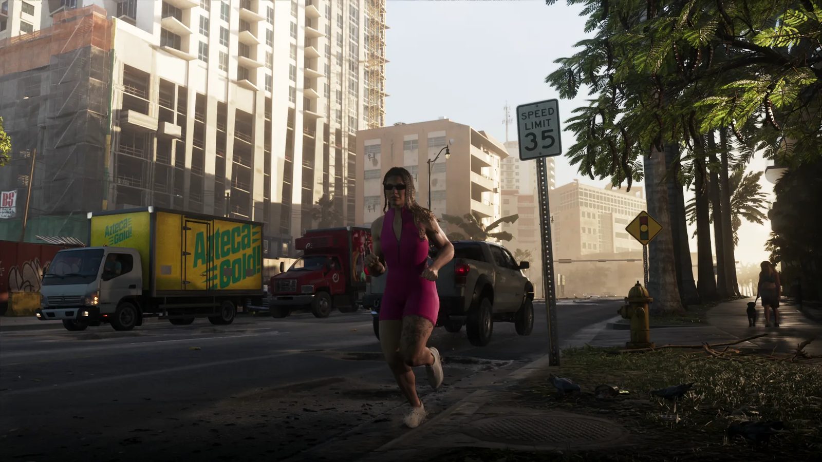 A woman in a pink sleeveless playsuit and sunglasses jogs along a sunlit city street past a yellow Azteca Gold delivery truck and a grey pickup.