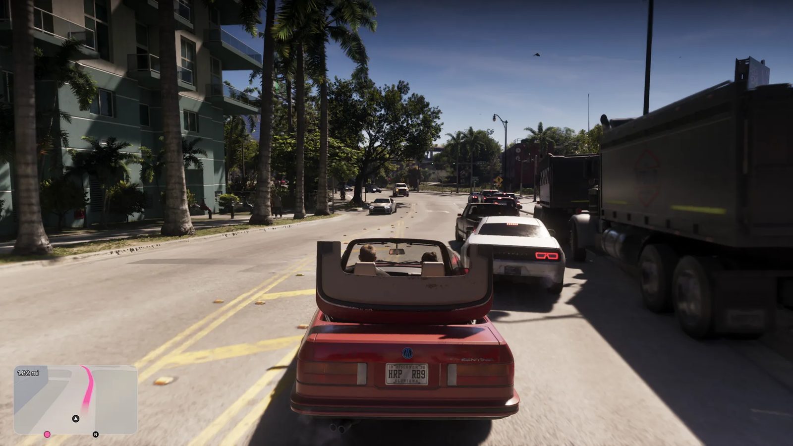 A red convertible with two people in it drives along a sunny, palm-lined street past a white car and a large dump truck, with a satnav map in the corner.