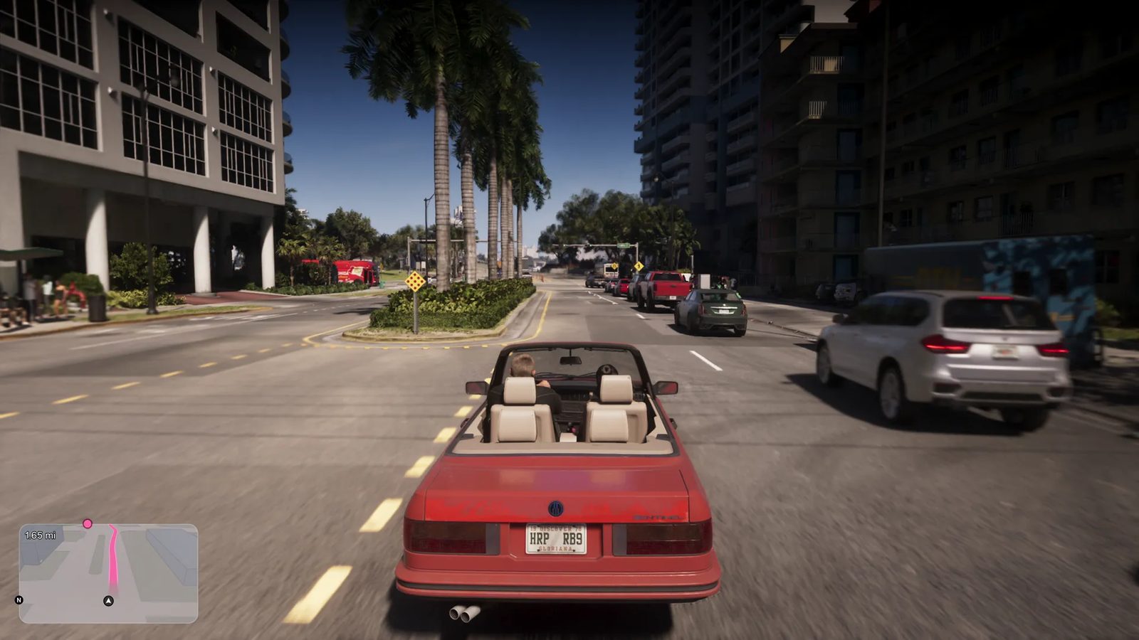 A red convertible with cream seats drives down a palm-lined city street in bright daylight, with a white SUV passing on the right and tower blocks either side.