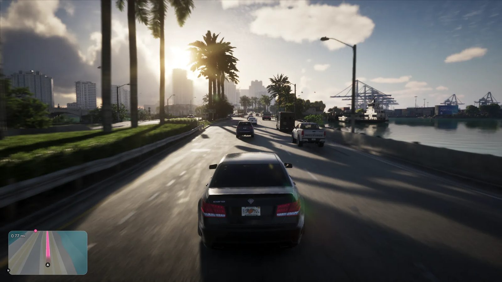 A black saloon car drives along a sunlit palm-lined waterfront road towards a skyline, with a harbour and cranes at VC Port on the right.