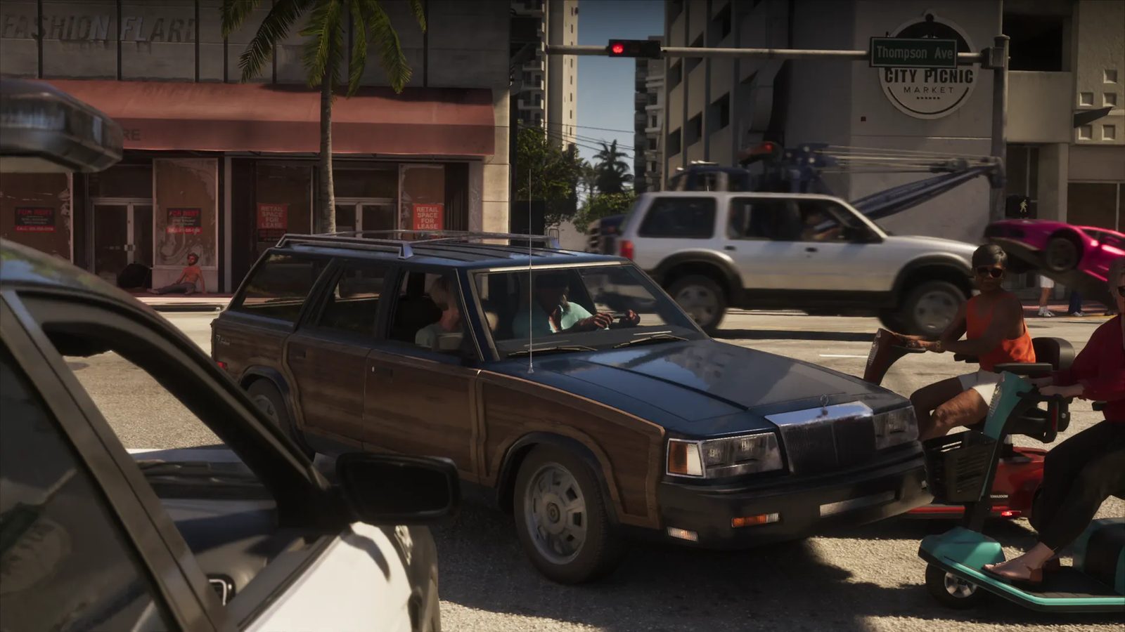 A dark blue station wagon with wood-effect panels waits at a junction as two people on mobility scooters pass, with a tow truck behind in Vice City.