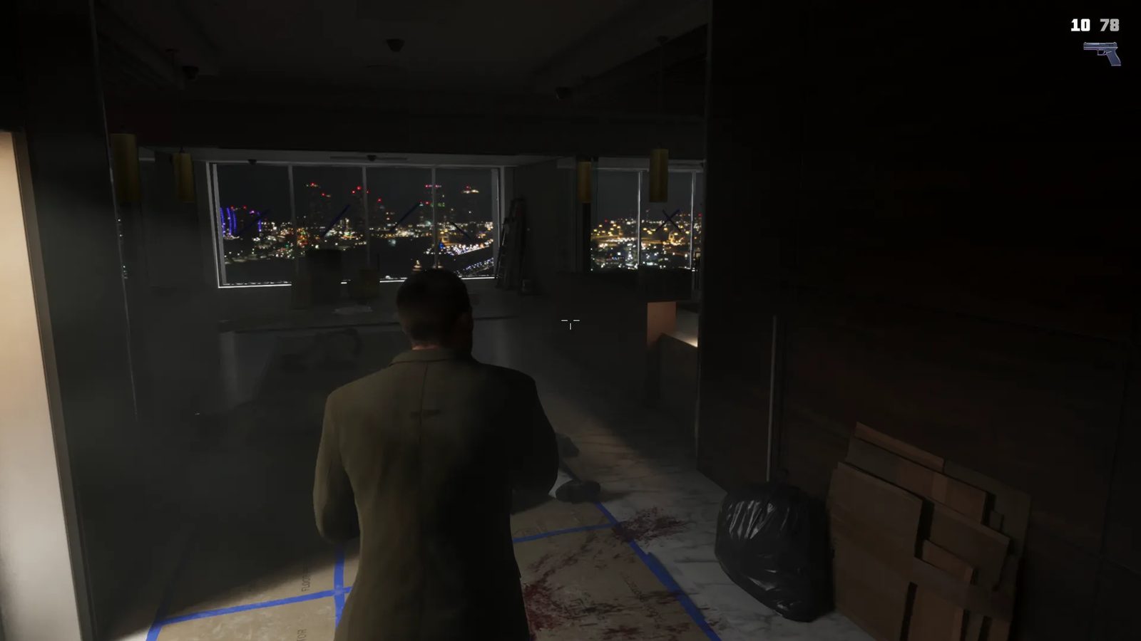 Seen from behind, Jason Duval stands in a dark, unfinished high-rise office at night, looking out over a glittering city skyline.