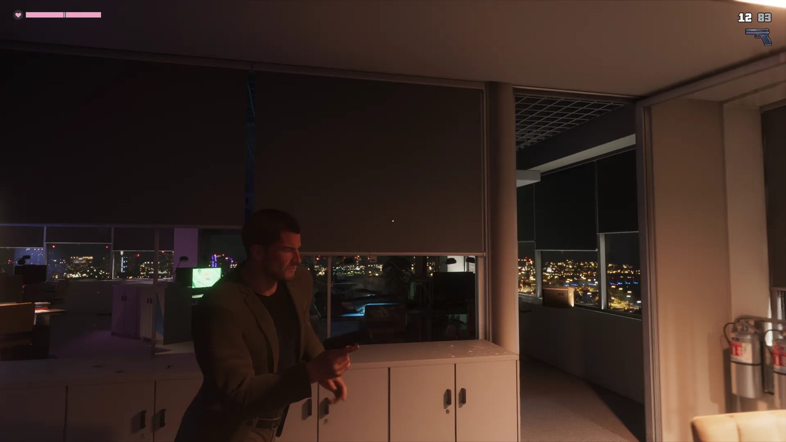 Jason Duval, in a dark olive jacket, moves through a dim office holding a pistol, with city lights glowing beyond the blinds at night.