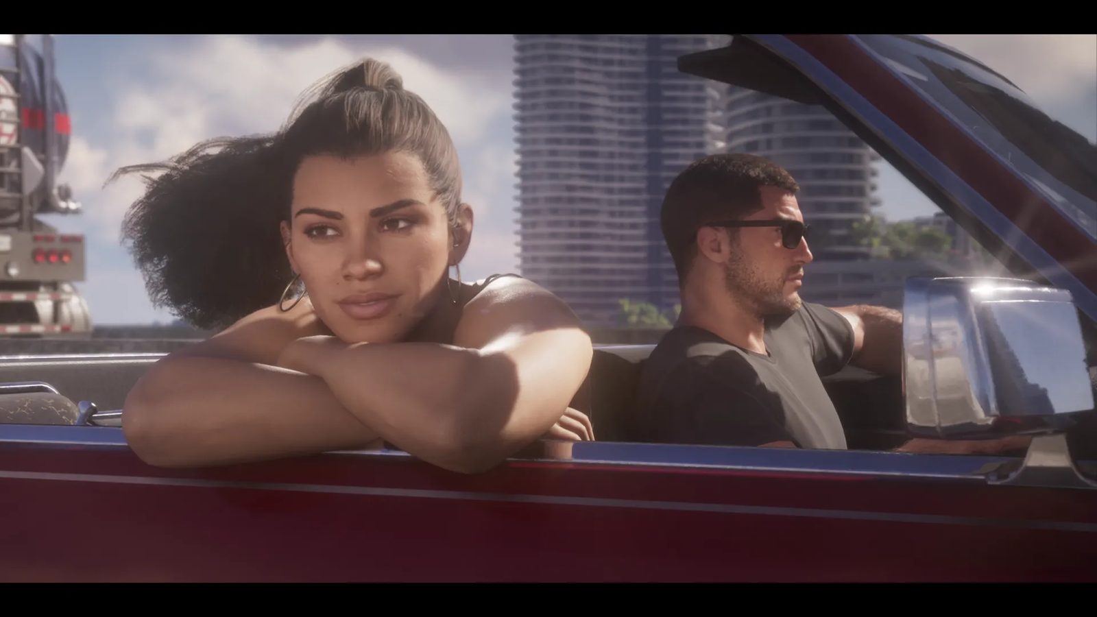 Lucia Caminos rests her arms on the door of a dark red convertible while Jason Duval drives beside her, with tall towers behind in daylight.