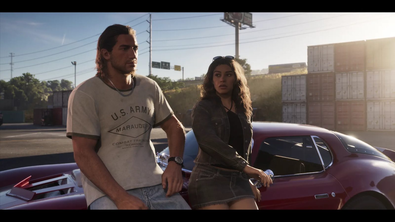Jason Duval and Lucia Caminos lean against a dark red sports car in a sunlit yard with stacked shipping containers behind them.
