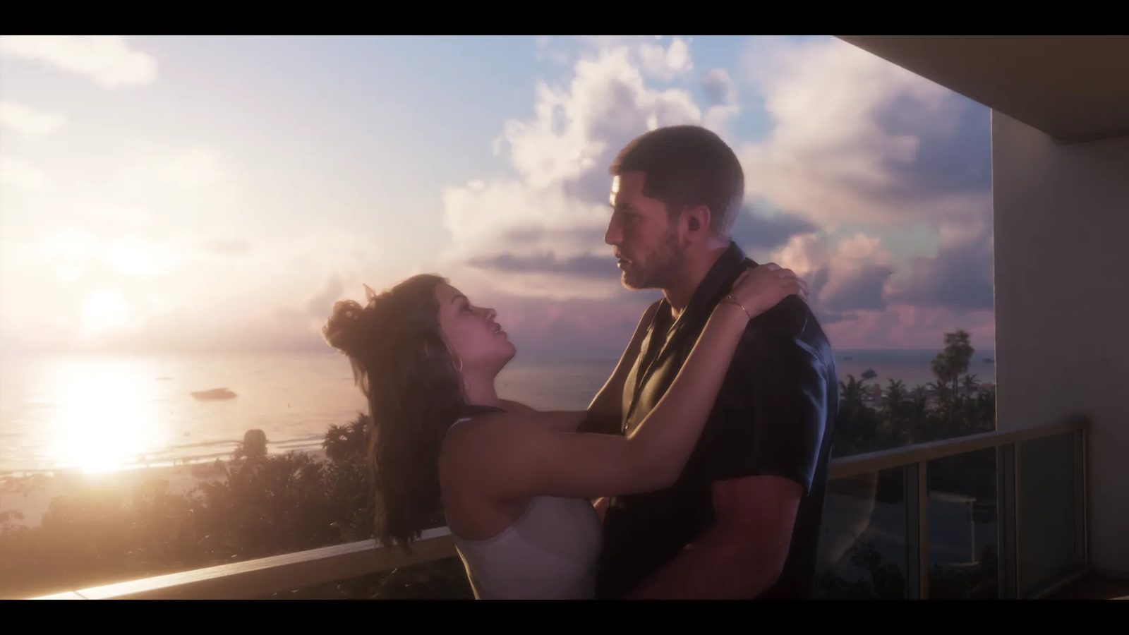 A man and a woman embrace on a hotel balcony at sunset, with the sea and palm trees behind them.