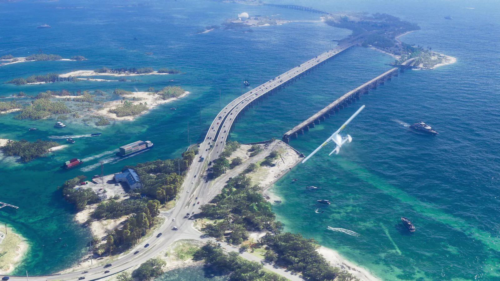 A white Mammoth Dodo seaplane banks over a long road bridge and a disused bridge linking green islands in the Leonida Keys, with turquoise water below.