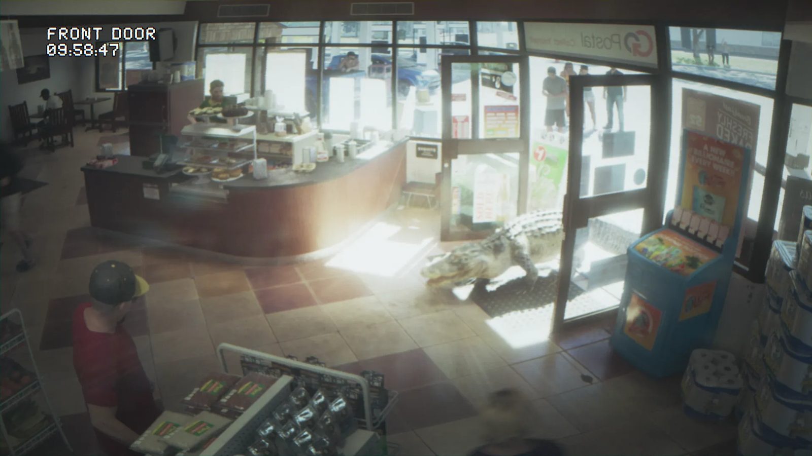 An alligator walks in through the open front door of a busy convenience store, seen on a security camera labelled "Front Door" with a timestamp.