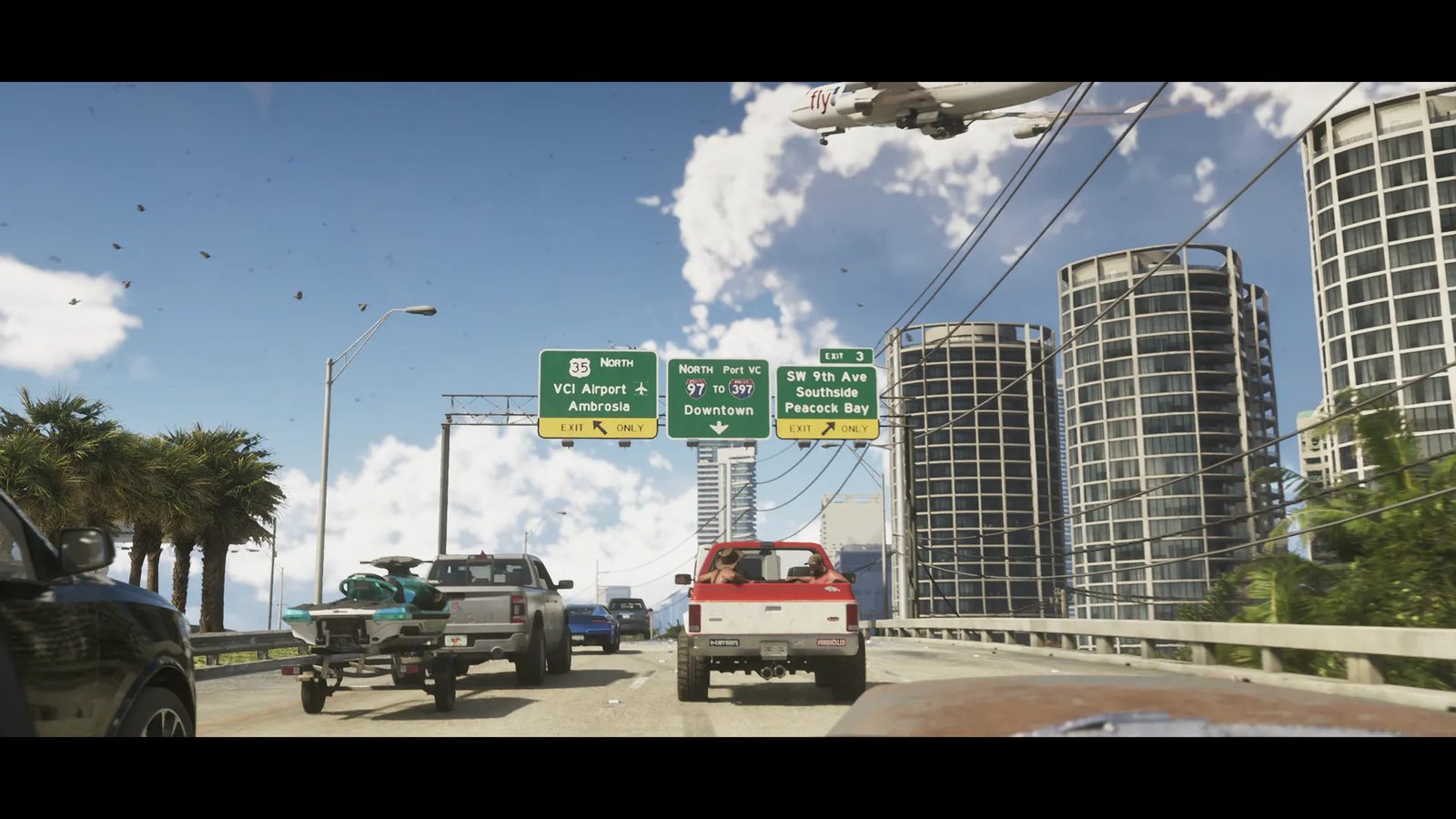 A red and white pickup truck leads traffic on a Vice City highway beneath green exit signs, with a jet flying low over tall round towers.