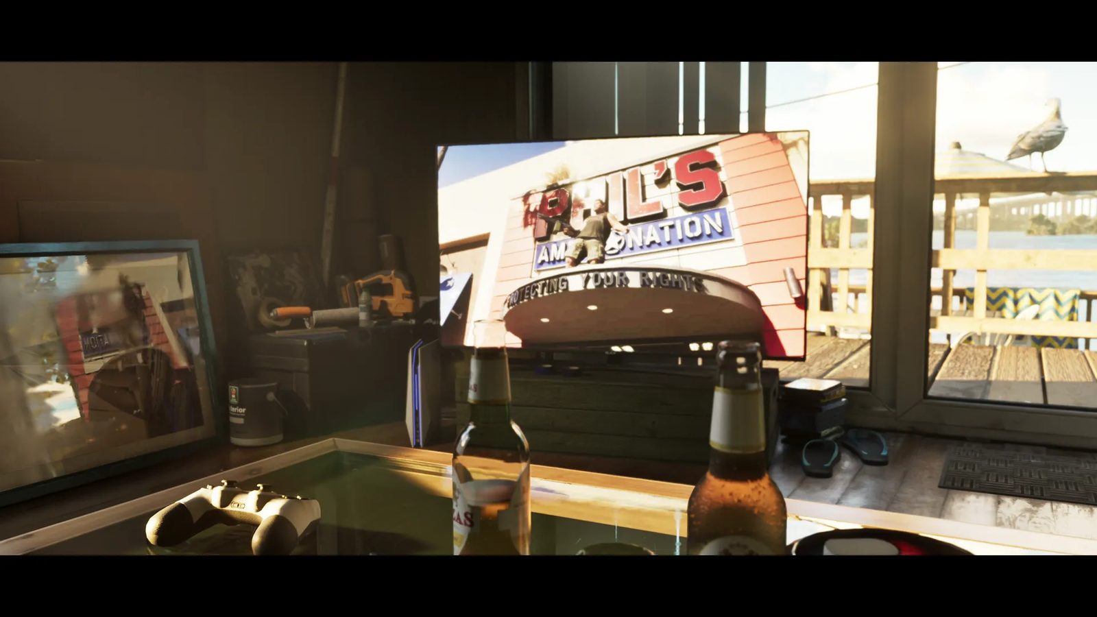 A television in a sunlit waterside room shows a Phil's Ammo Nation sign, with two beer bottles and a games controller on a table in front.