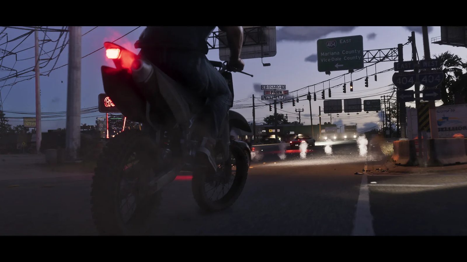 A rider on a dirt motorbike with a glowing red tail light waits on a road at dusk beneath signs for Mariana County and Vice-Dale County.