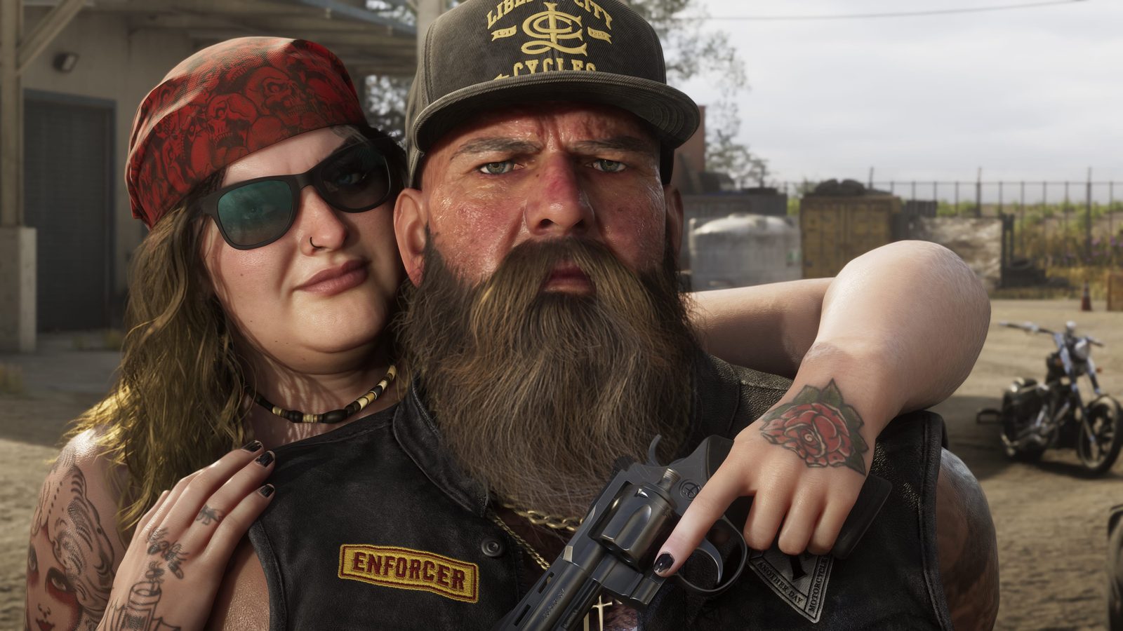A bearded man in a Liberty City Cycles cap and an "Enforcer" leather vest holds a revolver as a woman in a red bandana hugs him, outside in a dusty yard.