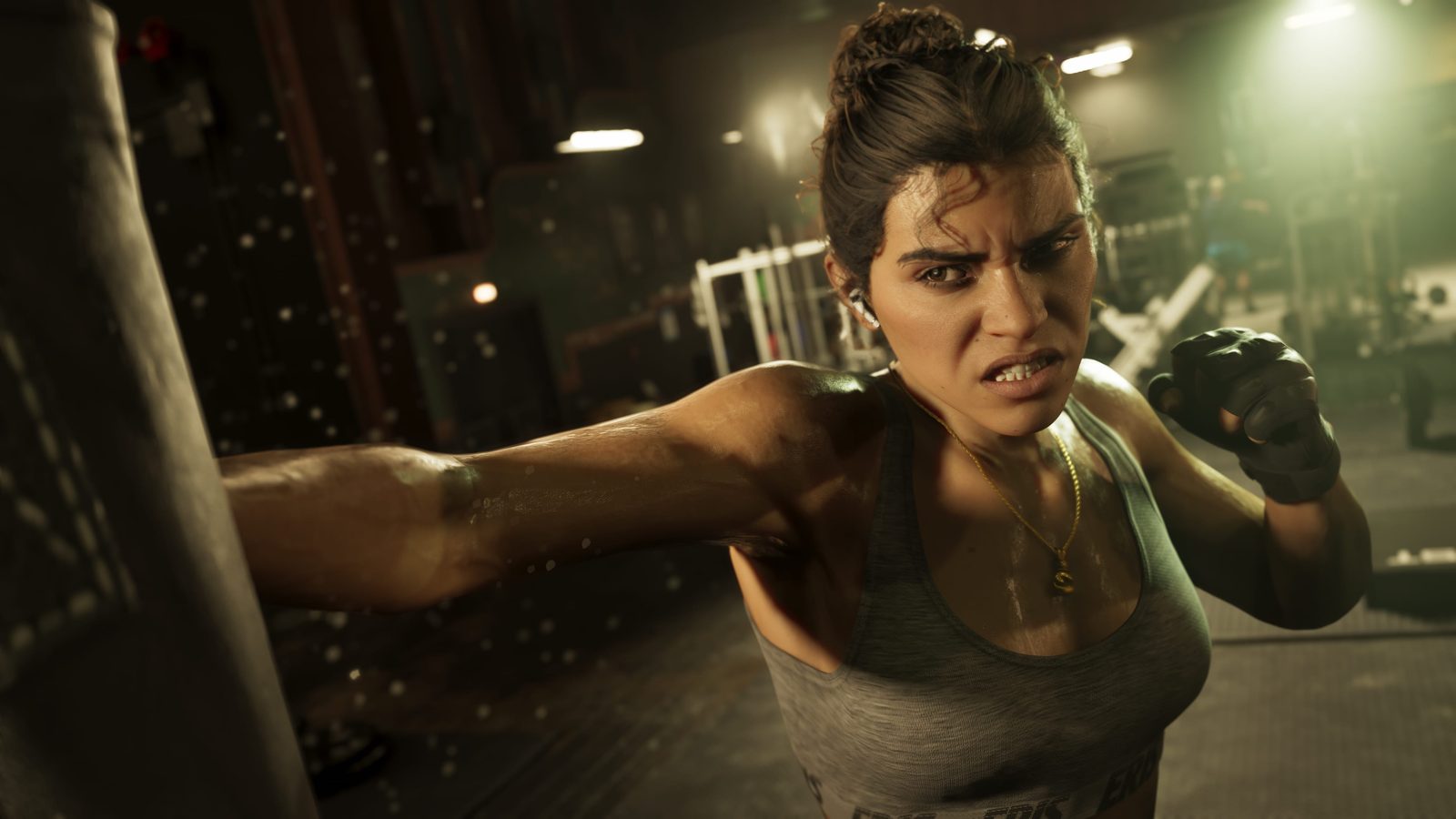 Lucia Caminos grimaces as she punches a heavy bag in a dimly lit gym, sweat flying, with weight equipment behind her.