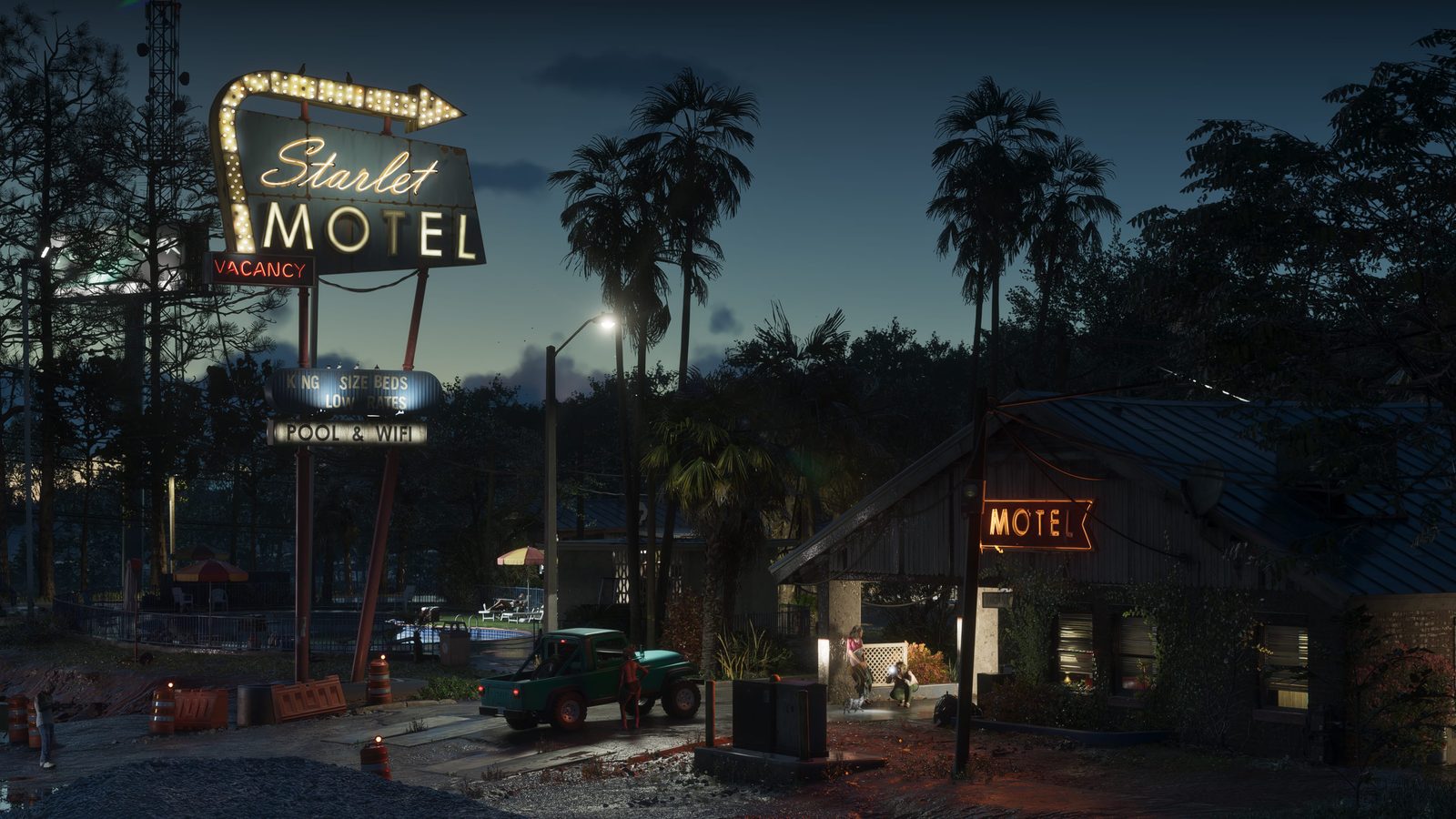 The Starlet Motel's lit sign and vacancy light glow beside a green pickup truck outside a low motel building at dusk, with palm trees behind.