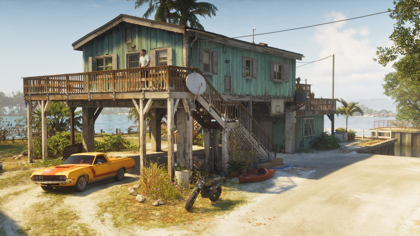Jason Duval stands on the deck of Jason's House, a teal stilt house by the water, with a Vapid Ganado, a Dinka Enduro and a Crest Kayak outside.