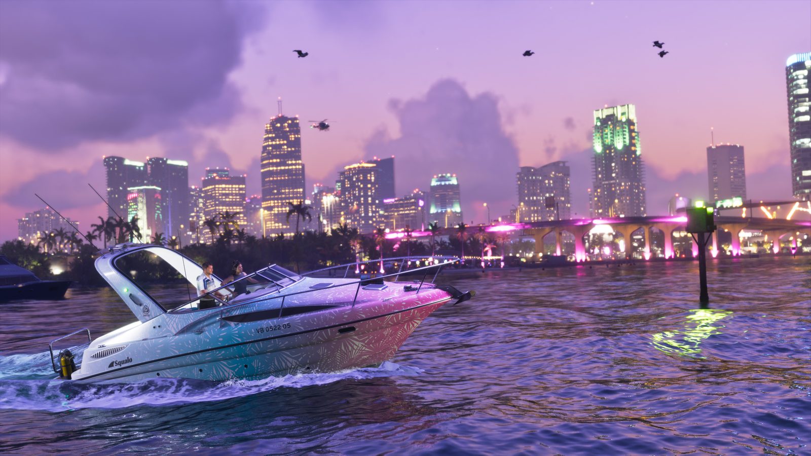 A man and a woman ride a white, pink and teal Squalo motor boat across dark water at dusk, with a lit city skyline and bridge behind.
