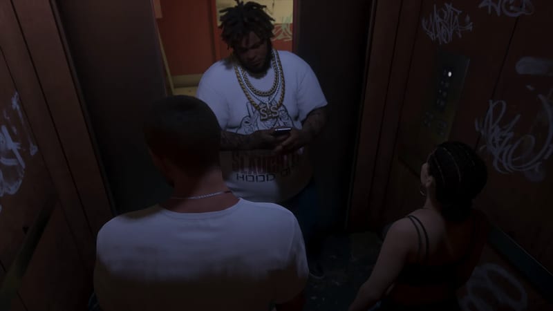 Three people crowd into a dim, graffiti-covered lift, where a large man in a white T-shirt and gold chains looks down at a phone.