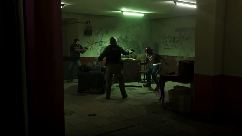 Two armed men and a police officer with his back to us aim pistols at a shirtless man in a red cap in a dim, green-lit, graffitied room.