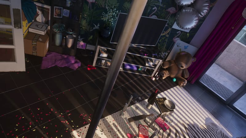 A messy flat interior seen from above, with a pole, a large teddy bear, a TV on a shelf unit and confetti on a dark tiled floor, in low sunlight.