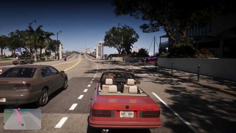 A red convertible with cream seats drives along a sunny, palm-lined road towards a bridge, with a brown saloon car alongside, in Vice City.