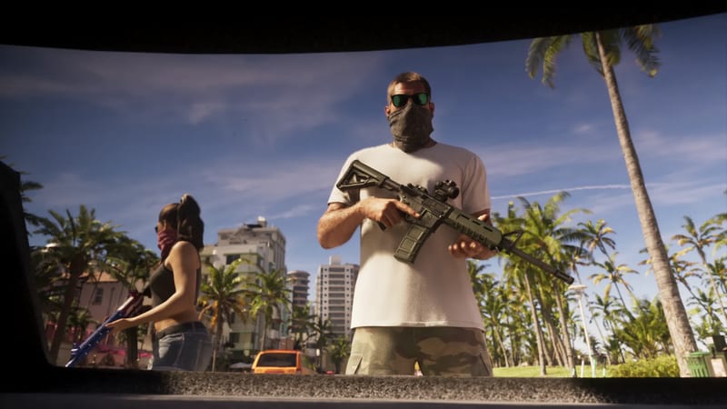 A masked man in sunglasses and a white T-shirt holds a rifle beside a masked woman, seen from inside a car boot, on a palm-lined street under a blue sky.