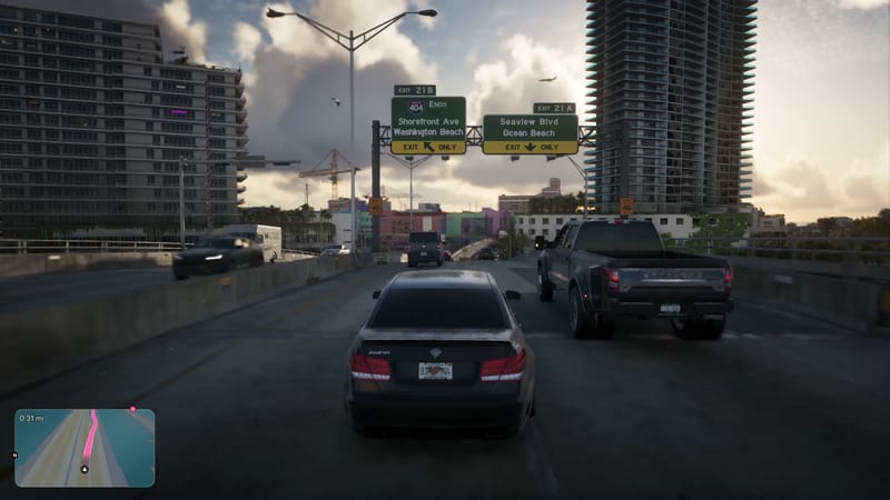 A dark grey saloon car seen from behind drives along an elevated road beside a black pickup, towards green exit signs for Shorefront Ave and Seaview Blvd.
