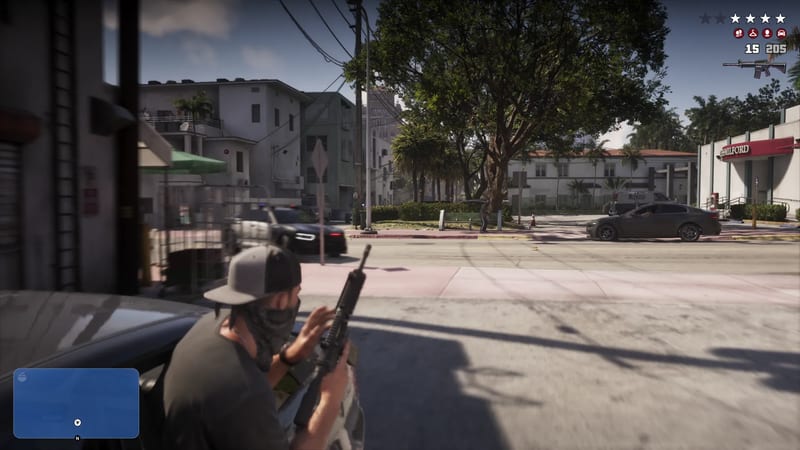 A masked man in a grey cap crouches behind a car holding a rifle on a sunlit Vice City street, with a dark police car and a grey saloon nearby.
