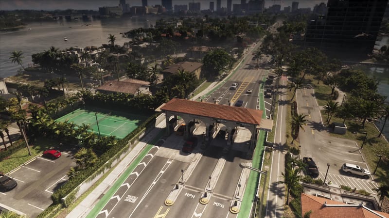A toll plaza with a red tiled roof spans a wide road beside a green tennis court, with palm trees, villas and a waterfront in Vice City.