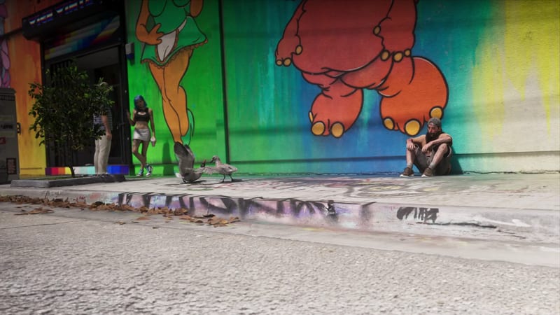 A bearded man in a backwards cap sits against a colourful mural while two gulls squabble on the pavement and a woman with blue hair walks by.