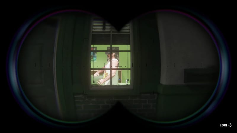 Through binoculars, a man in a white vest and headset stands in a lit green room, seen through a window at night.