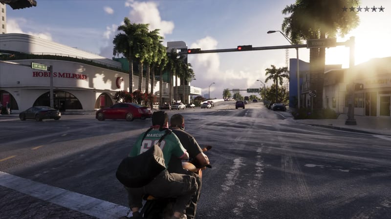 Two people ride a motorbike towards a junction with traffic lights, palm trees and a red car, in low evening sun.