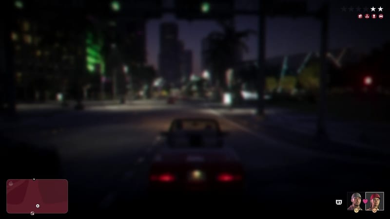 A dark red convertible drives along a wide Vice City street at night, with palm trees and tall buildings ahead, seen heavily blurred.
