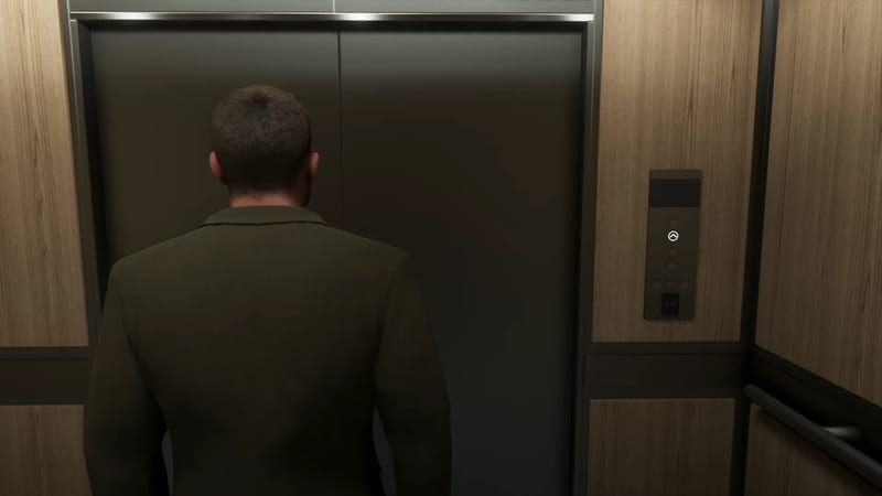 Jason Duval stands with his back to us in a wood-panelled lift, facing closed dark metal doors.