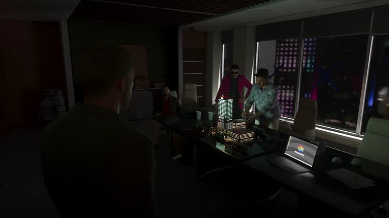 Men gather around a lit model of a tower block on a table in a dark office at night, with a Megamundo laptop in the foreground.