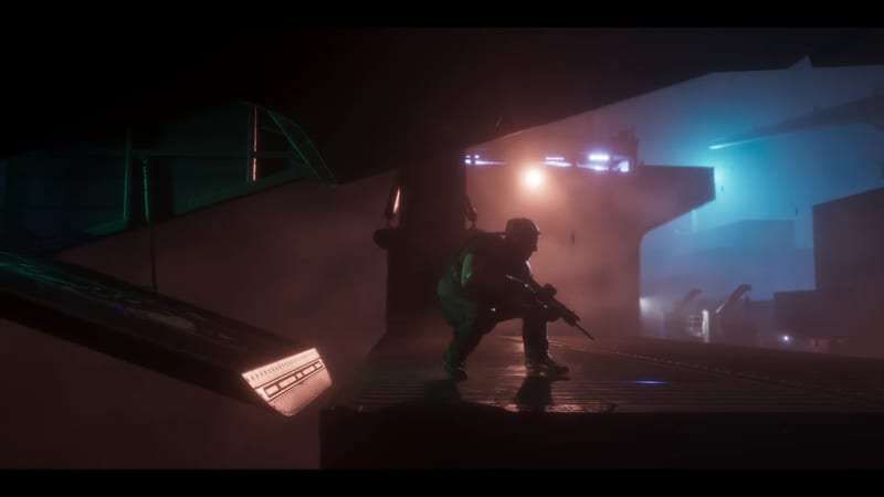 A crouching armed figure in helmet and combat gear takes cover on a wet metal deck in thick fog, lit by orange and blue lights.