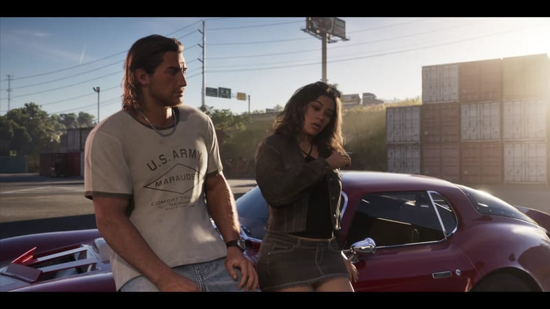 A long-haired man in a grey U.S. Army T-shirt and a woman in a denim jacket lean against a dark red sports car in a sunlit container yard.