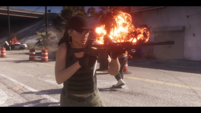 Lucia Caminos, in a black cap and vest, aims a rifle on a coned-off road as a fireball erupts behind her and a police car burns.