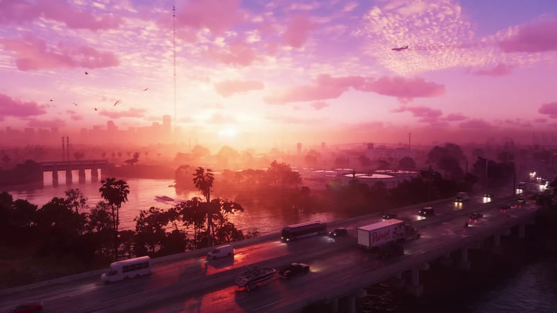 Traffic crosses an elevated road beside a river at sunset, with a Patriot lorry, a bus and a boat on a trailer, and a hazy city skyline beyond.