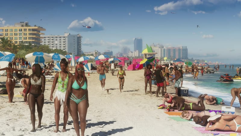 Crowds of sunbathers and walkers on a wide white sandy beach at Ocean Beach, with striped parasols, jet skis in the surf and hotels behind.