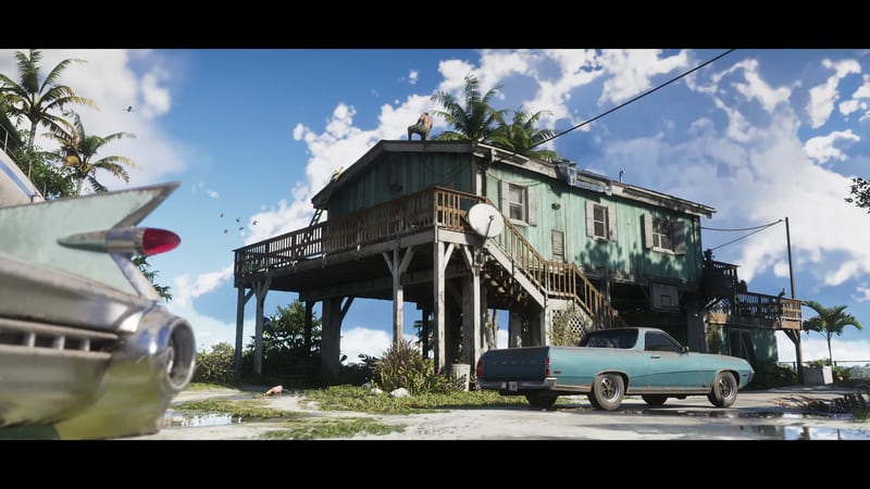 A green wooden house on stilts with a man crouched on its roof, a rusty teal Vapid pickup parked below and a classic car's tail fin in the foreground.