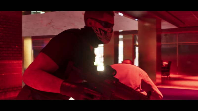 A masked man in dark clothing and sunglasses crouches with a rifle in a red-lit lobby, while a bald man in a white shirt bends over behind him.