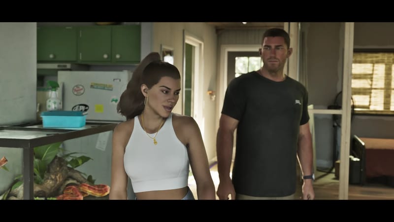 Lucia Caminos in a white crop top looks aside while Jason Duval stands behind her in a small, cluttered house interior.