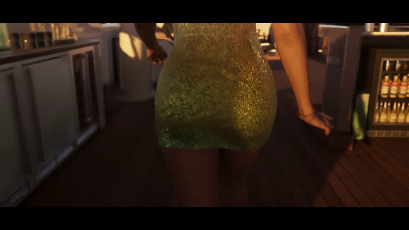 A woman in a short, sparkly green sequinned dress walks away from the camera along a wooden deck beside a bar at golden hour.