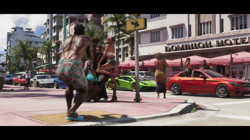 Beachgoers dance on a pink pavement beside a red saloon car and a green sports car outside the Dominion Hotel on a sunny, palm-lined street.