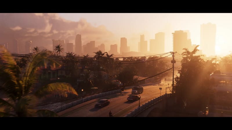 A hazy golden sunset over the Vice City skyline, with cars crossing a bridge on a palm-lined road in the foreground.