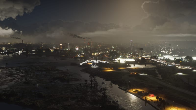 Ambrosia at night: a lit town and smoking industrial chimneys beyond a dark marshland and winding river under heavy cloud.