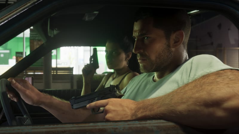 Jason Duval grips a pistol at the wheel of a rusty car while Lucia Caminos sits behind him holding a handgun, both looking tensely ahead.