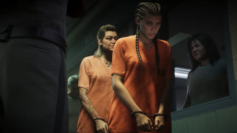 Lucia Caminos, in an orange prison uniform and handcuffs, walks head down in a line of inmates past a uniformed guard in a dim corridor.