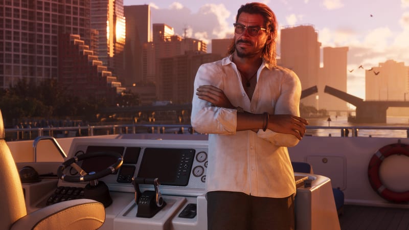 Raul Bautista stands with his arms folded beside the controls of a yacht at sunset, with city towers and a raised bridge behind him.