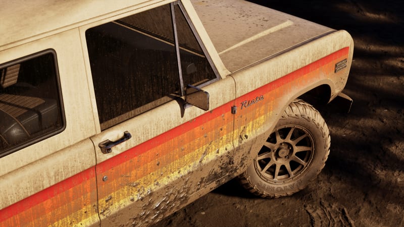 Close-up of a mud-splattered cream Vapid Riata Classic with red, orange and yellow side stripes, parked on dark muddy ground.